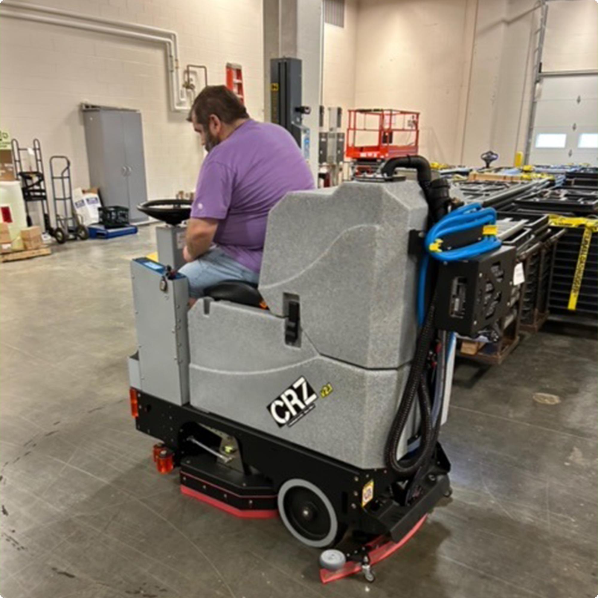 Tomcat CRZ 34" Disk Deck Ride On Floor Scrubber cleaning concrete in the warehouse of a high school IMG00038