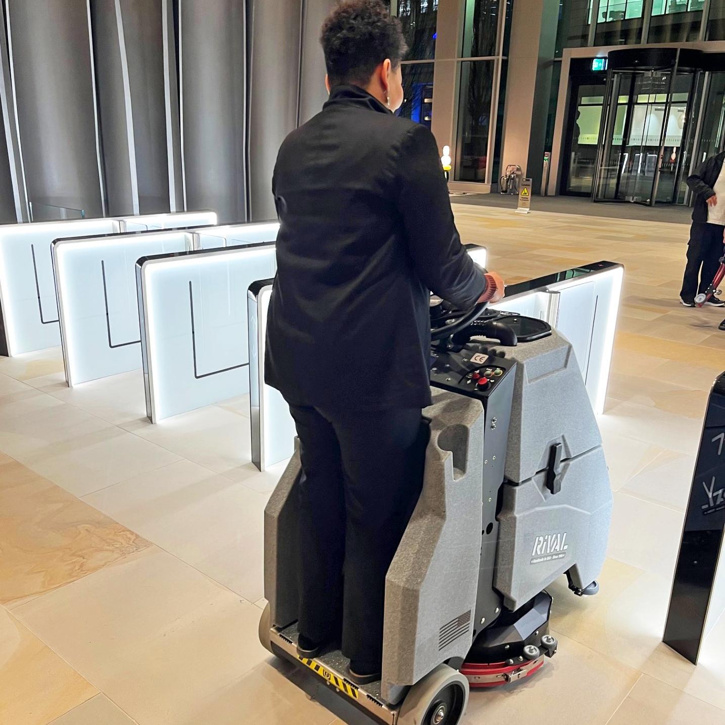 A Tomcat Rival stand on floor scrubber easily cleans the high traffic pedestrian lanes in an office building entrance.
