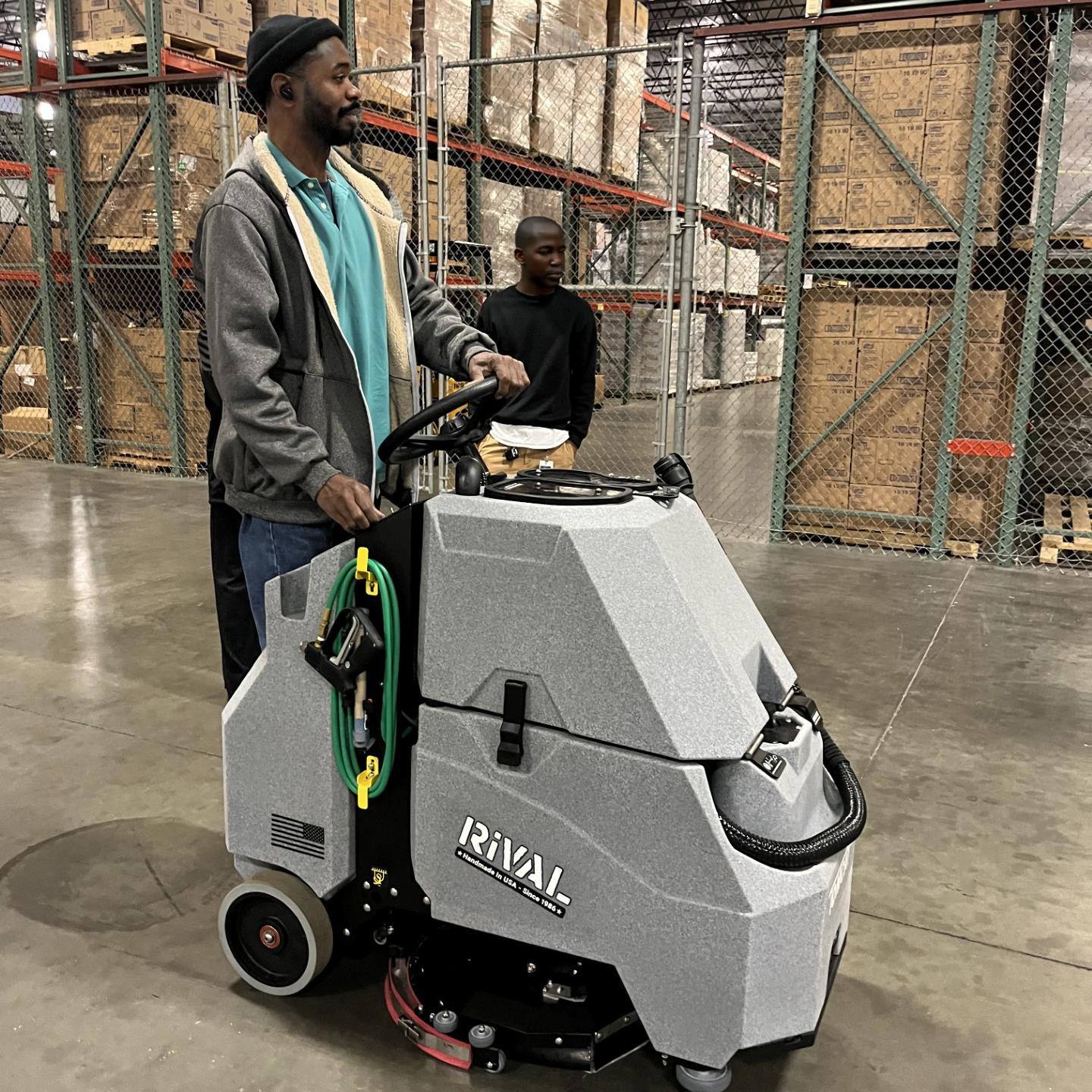 The Tomcat Rival stand up auto scrubber cleans the concrete floor in a school district warehouse in Texas. 
