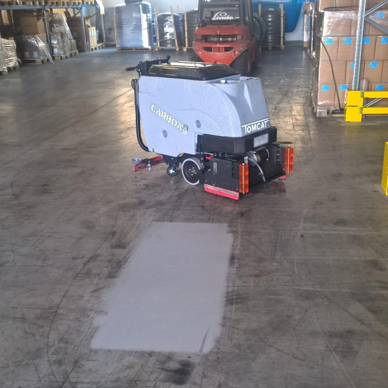 Tomcat Walk Behind Floor Scrubbers Carbon warehouse concrete CARBON Walk Behind Floor Scrubber cleaning the warehouse concrete floor of a Savanah, Georgia machine shop