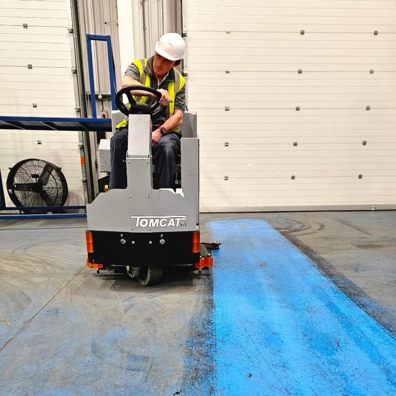 Tomcat Ride On Floor Scrubbers EX loading dock epoxy A Tomcat EX ride on battery floor scrubber cleaning the filthy loading dock epoxy floors at a manufacturer in Europe