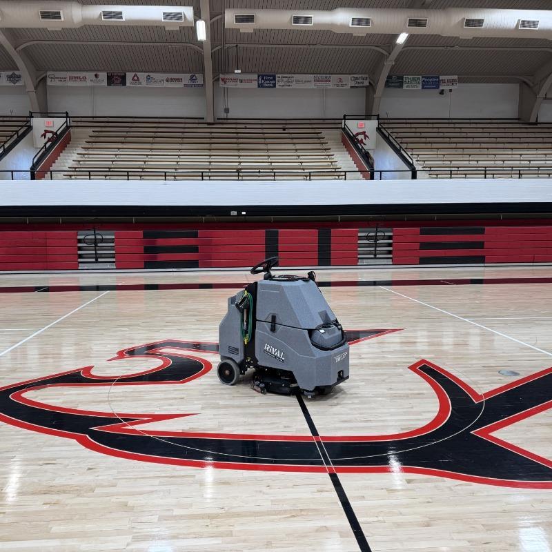 Tomcat Stand On Floor Scrubbers Rival basketball courts wood gym floor A Tomcat Rival stand on battery floor scrubber cleaning the wood gym floor of a basketball court in Dayton, OH.