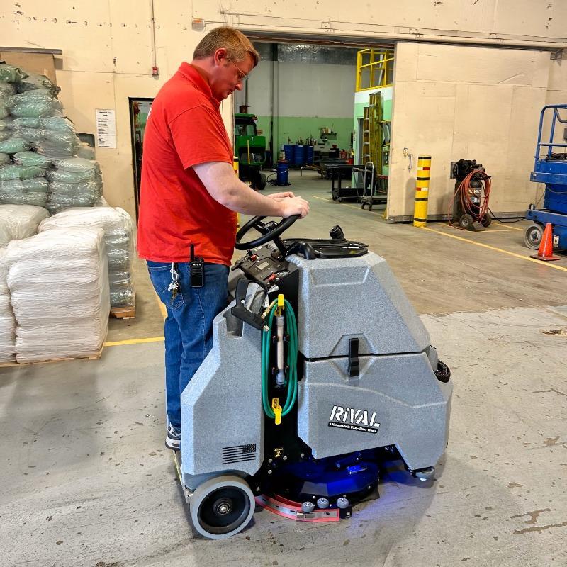 Tomcat Stand On Floor Scrubbers Rival warehouse concrete A Tomcat Rival Stand On Floor Scrubber cleans the epoxy floor of a warehouse in a Wheeling, Illinois cleaning and janitorial supply house